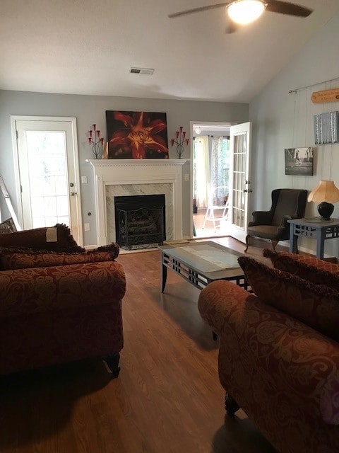 living room featuring a fireplace, hardwood / wood-style flooring, vaulted ceiling, and a healthy amount of sunlight