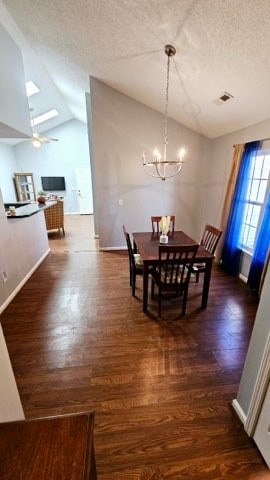 dining area featuring a textured ceiling, dark hardwood / wood-style flooring, lofted ceiling, and a notable chandelier