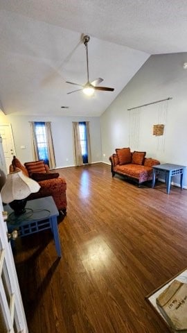 living room with a textured ceiling, ceiling fan, dark wood-type flooring, and vaulted ceiling