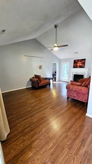 interior space featuring a textured ceiling, ceiling fan, dark hardwood / wood-style flooring, and lofted ceiling