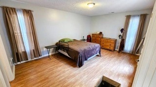 bedroom featuring hardwood / wood-style flooring and a textured ceiling