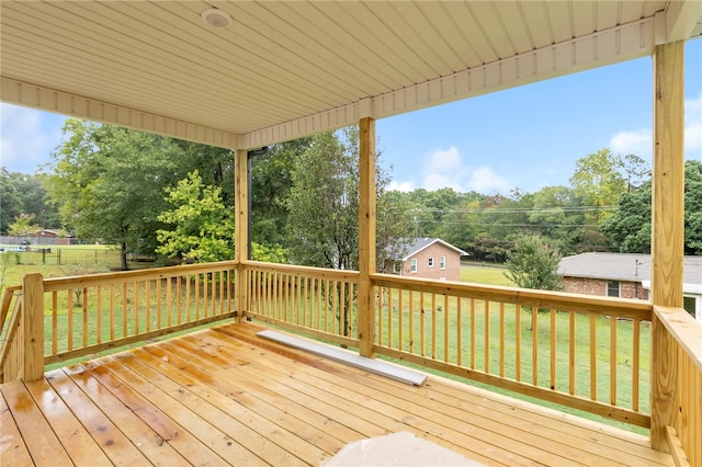 wooden terrace featuring a lawn