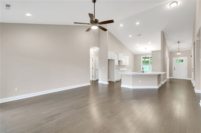 unfurnished living room featuring high vaulted ceiling, ceiling fan with notable chandelier, and dark hardwood / wood-style floors