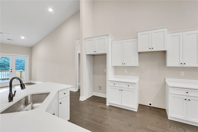 kitchen with dark hardwood / wood-style flooring, white cabinetry, sink, and vaulted ceiling