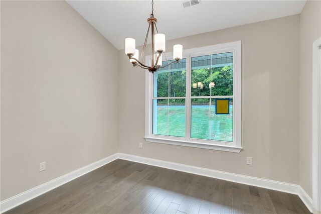 unfurnished room with dark hardwood / wood-style floors and a notable chandelier