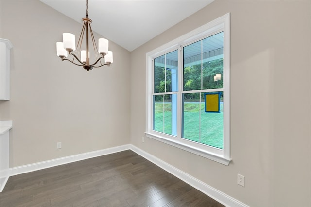 unfurnished dining area with dark wood-type flooring, vaulted ceiling, and a notable chandelier