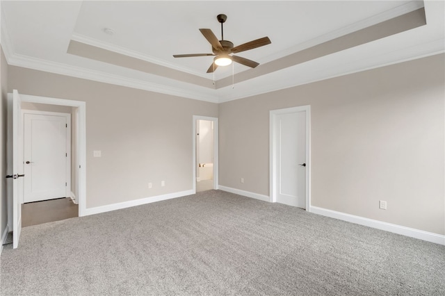 carpeted spare room featuring ornamental molding, ceiling fan, and a tray ceiling