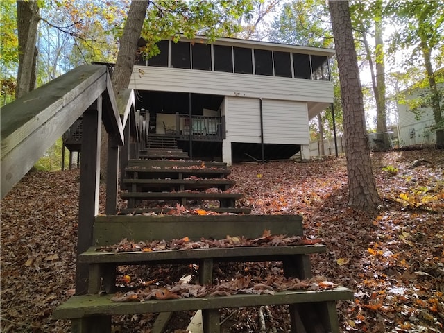 rear view of property featuring a sunroom