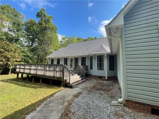 exterior space with a front yard and a wooden deck