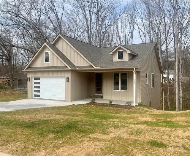 view of front of property with a garage, concrete driveway, a front lawn, and a shingled roof