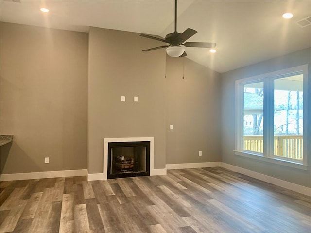 unfurnished living room with a fireplace, baseboards, and wood finished floors