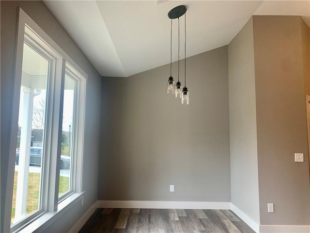 unfurnished dining area with dark wood-style floors, baseboards, and vaulted ceiling