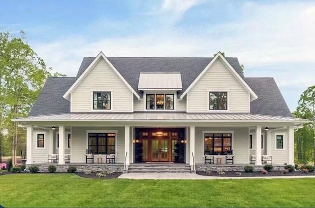 rear view of house with covered porch and a yard