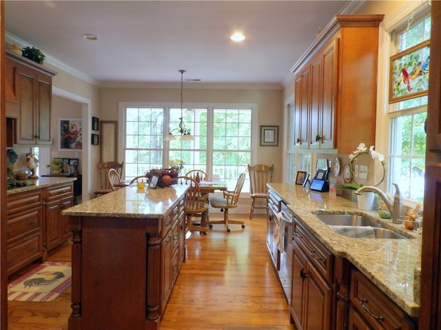 kitchen with light stone countertops, light hardwood / wood-style flooring, crown molding, and sink