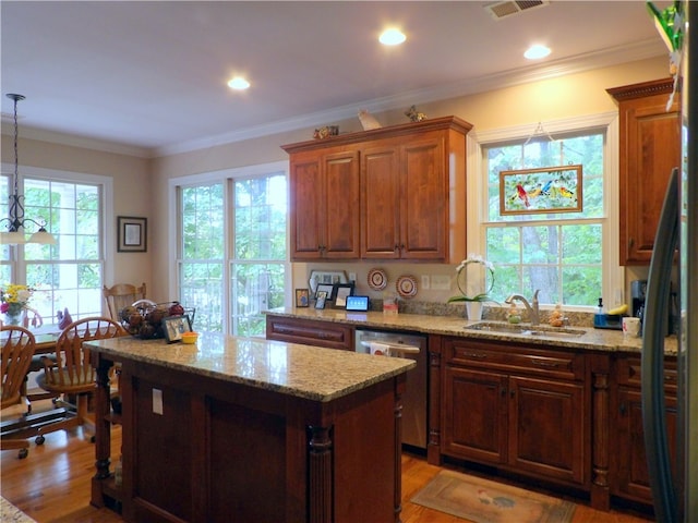 kitchen with ornamental molding, stainless steel dishwasher, sink, and a healthy amount of sunlight