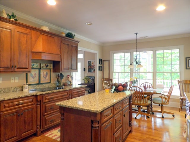 kitchen with custom range hood, hanging light fixtures, ornamental molding, and black electric cooktop