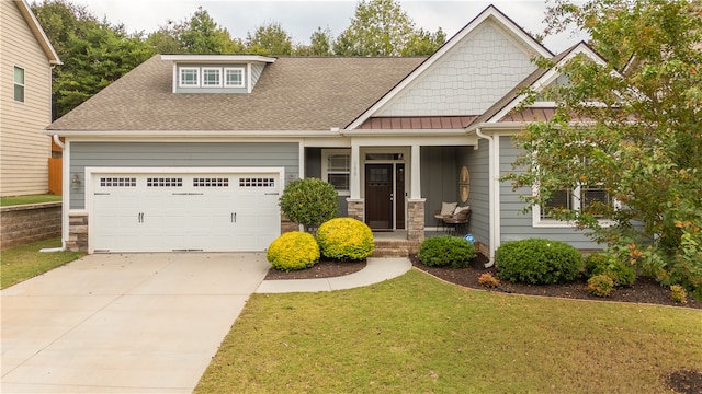 craftsman inspired home with a front lawn, a porch, and a garage