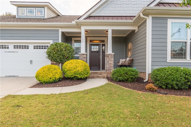 property entrance with a garage, a yard, and covered porch