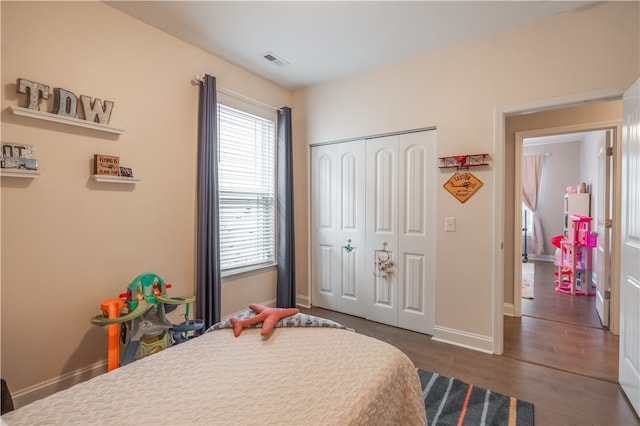 bedroom with dark hardwood / wood-style floors and a closet