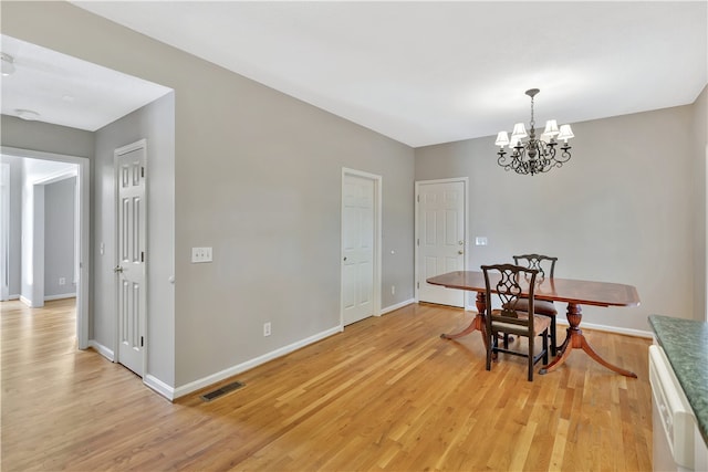 dining room featuring light hardwood / wood-style flooring and a chandelier