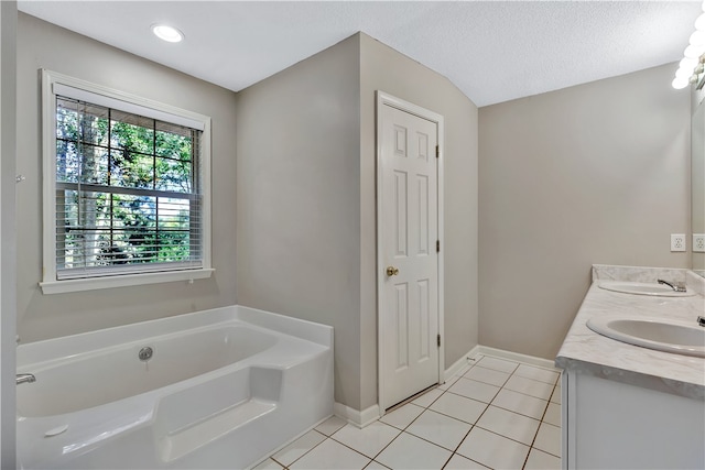 bathroom featuring a textured ceiling, vanity, a tub, and tile patterned floors