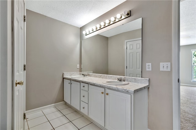 bathroom featuring vanity, tile patterned flooring, and a textured ceiling