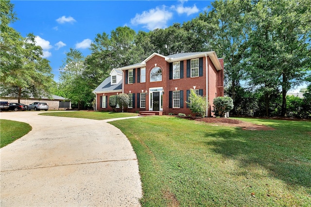 colonial-style house featuring a front yard