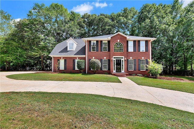 colonial home featuring a front lawn