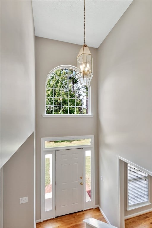 entryway featuring light hardwood / wood-style flooring and a chandelier