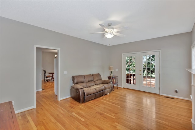 living room featuring ceiling fan, light hardwood / wood-style flooring, and french doors