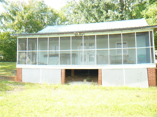 view of property exterior with a sunroom and a lawn