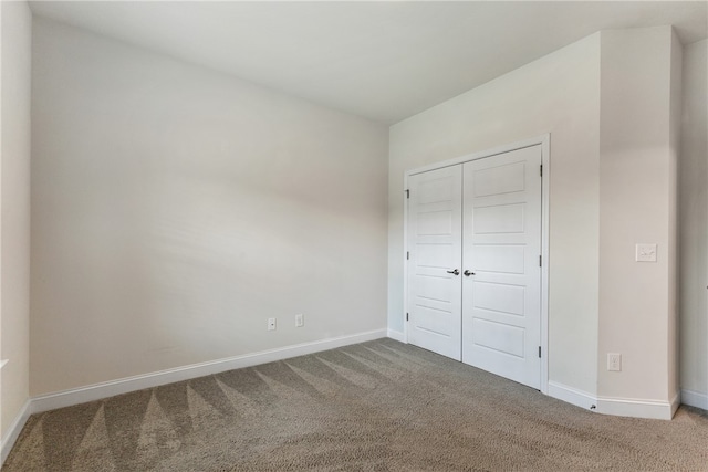 unfurnished bedroom with a closet and carpet flooring