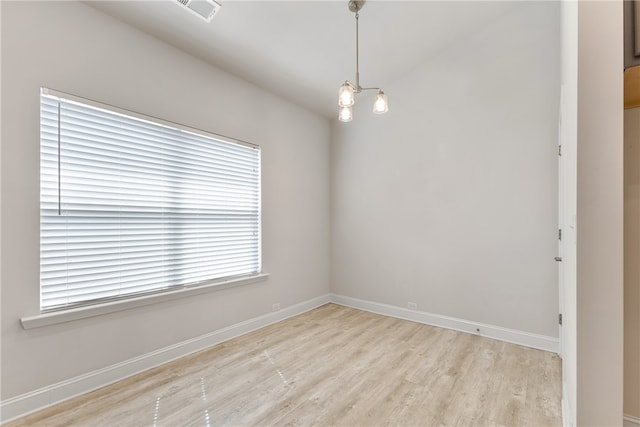 empty room with an inviting chandelier and light wood-type flooring