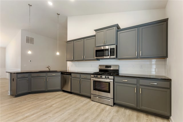 kitchen with pendant lighting, decorative backsplash, appliances with stainless steel finishes, and gray cabinets