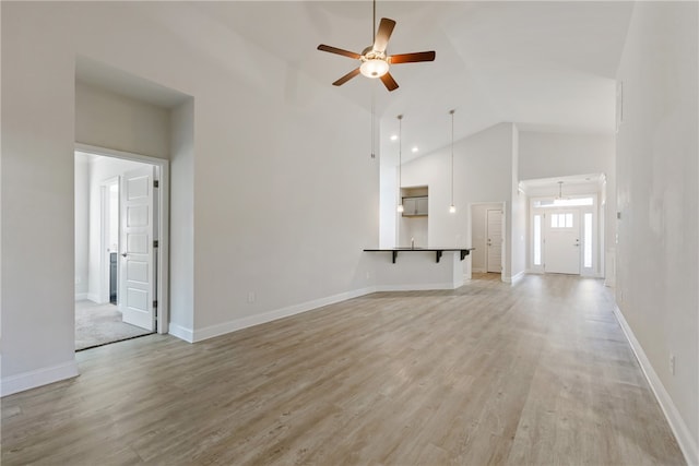 unfurnished living room featuring ceiling fan, light wood-type flooring, and high vaulted ceiling