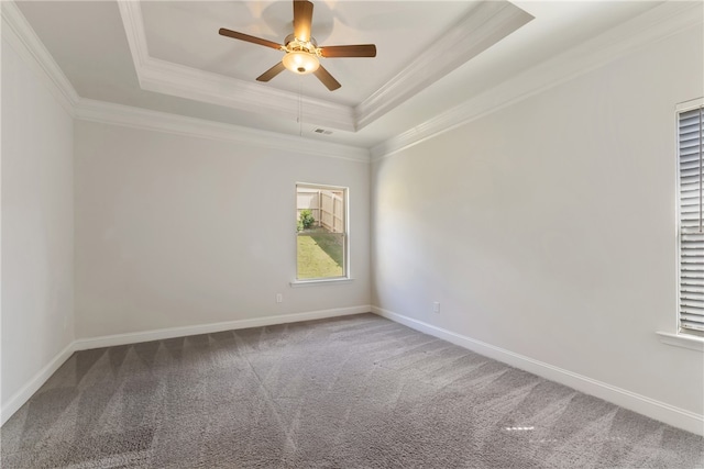 carpeted spare room featuring crown molding, a tray ceiling, and ceiling fan