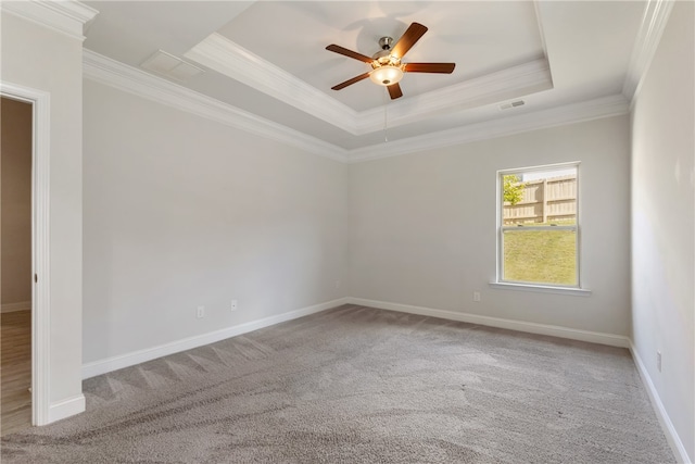 carpeted empty room with a tray ceiling, ceiling fan, and crown molding