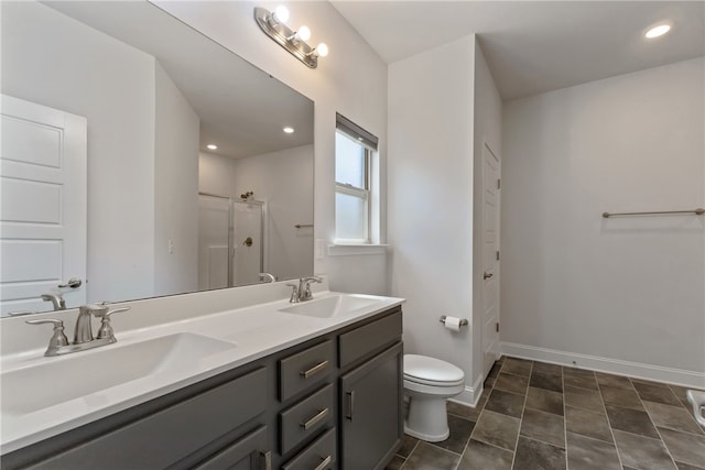 bathroom with vanity, toilet, and a shower with door