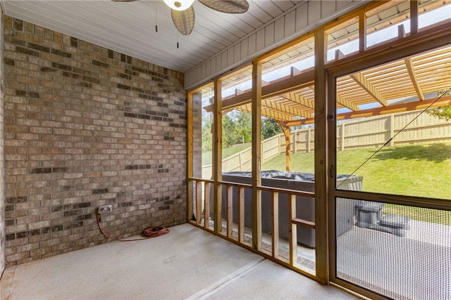 unfurnished sunroom with ceiling fan