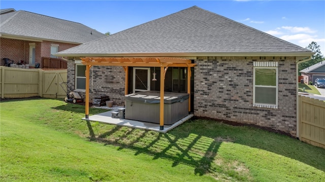 back of house with a hot tub and a yard