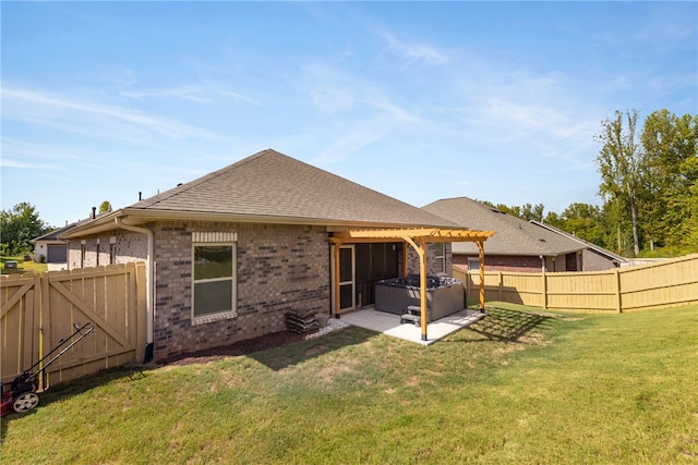 rear view of house featuring a lawn, a hot tub, and a patio