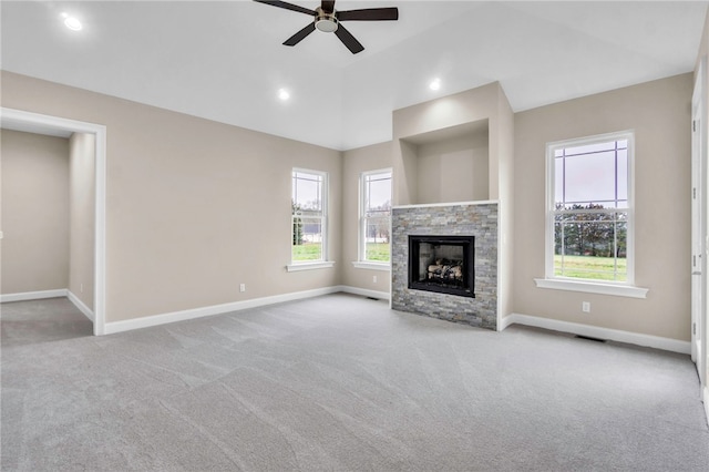 unfurnished living room with ceiling fan, light colored carpet, and a fireplace