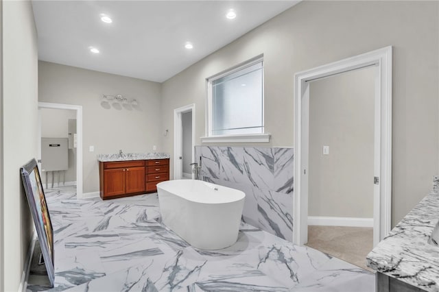 bathroom with tile walls, a washtub, and vanity