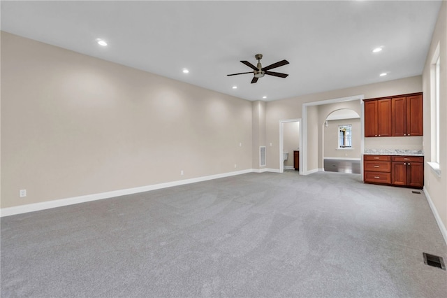 unfurnished living room featuring ceiling fan and light colored carpet