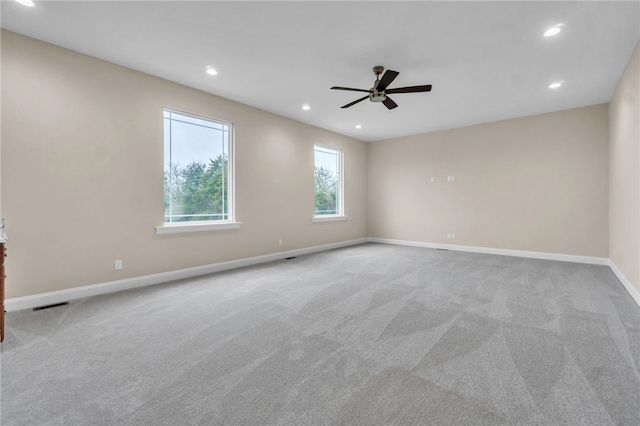 spare room with ceiling fan and light colored carpet