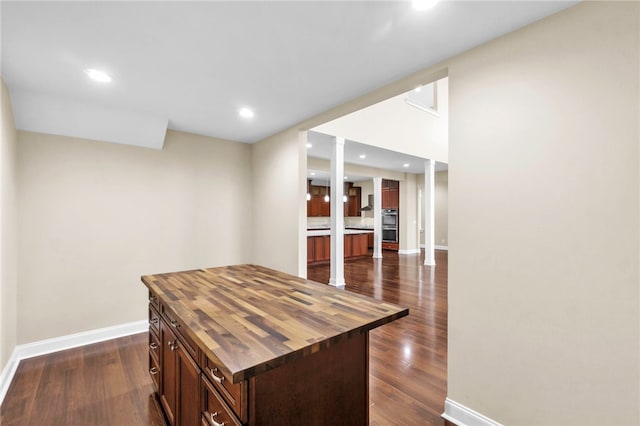 kitchen with a center island, wood counters, and dark wood-type flooring