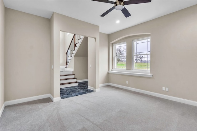 unfurnished living room with ceiling fan and dark colored carpet