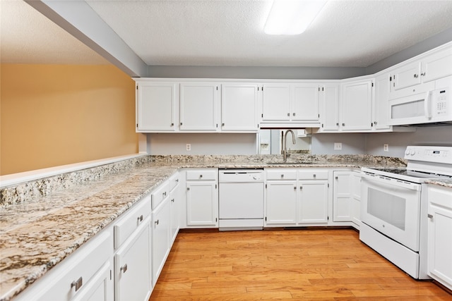 kitchen featuring sink, white appliances, a textured ceiling, light hardwood / wood-style flooring, and white cabinetry