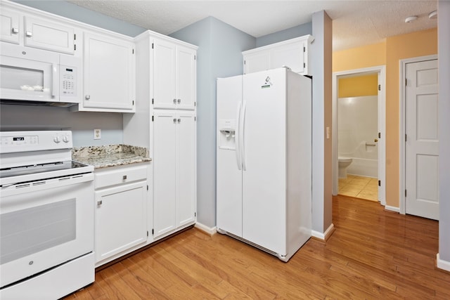 kitchen with a textured ceiling, light hardwood / wood-style flooring, white appliances, and white cabinetry