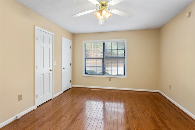 unfurnished room featuring ceiling fan, hardwood / wood-style floors, and a textured ceiling